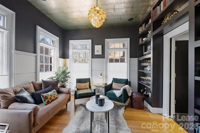 a living room with fireplace furniture and a large window