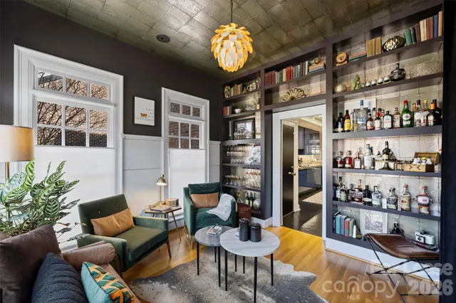 a living room with furniture a chandelier and a book shelf