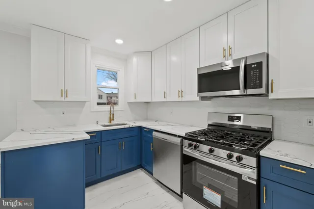 a kitchen with stainless steel appliances granite countertop a sink dishwasher a stove top oven a refrigerator with white cabinets and wooden floor