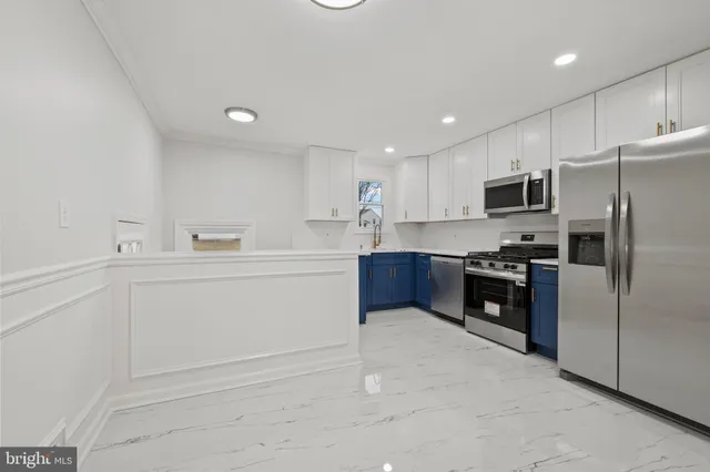 a kitchen with white cabinets and stainless steel appliances