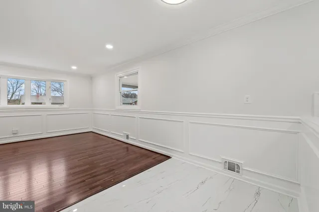 a view of a hallway with wooden floor and closet