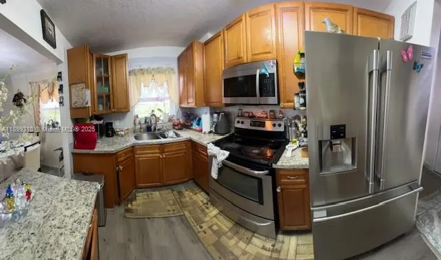 a kitchen with stainless steel appliances granite countertop a stove refrigerator and microwave