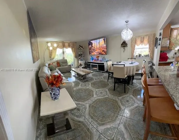 a living room with furniture a window and a flat screen tv