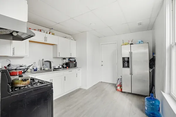 a kitchen with granite countertop a refrigerator and a stove top oven