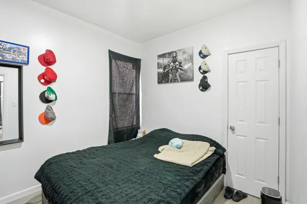 a bedroom with a bed and painting on the wall