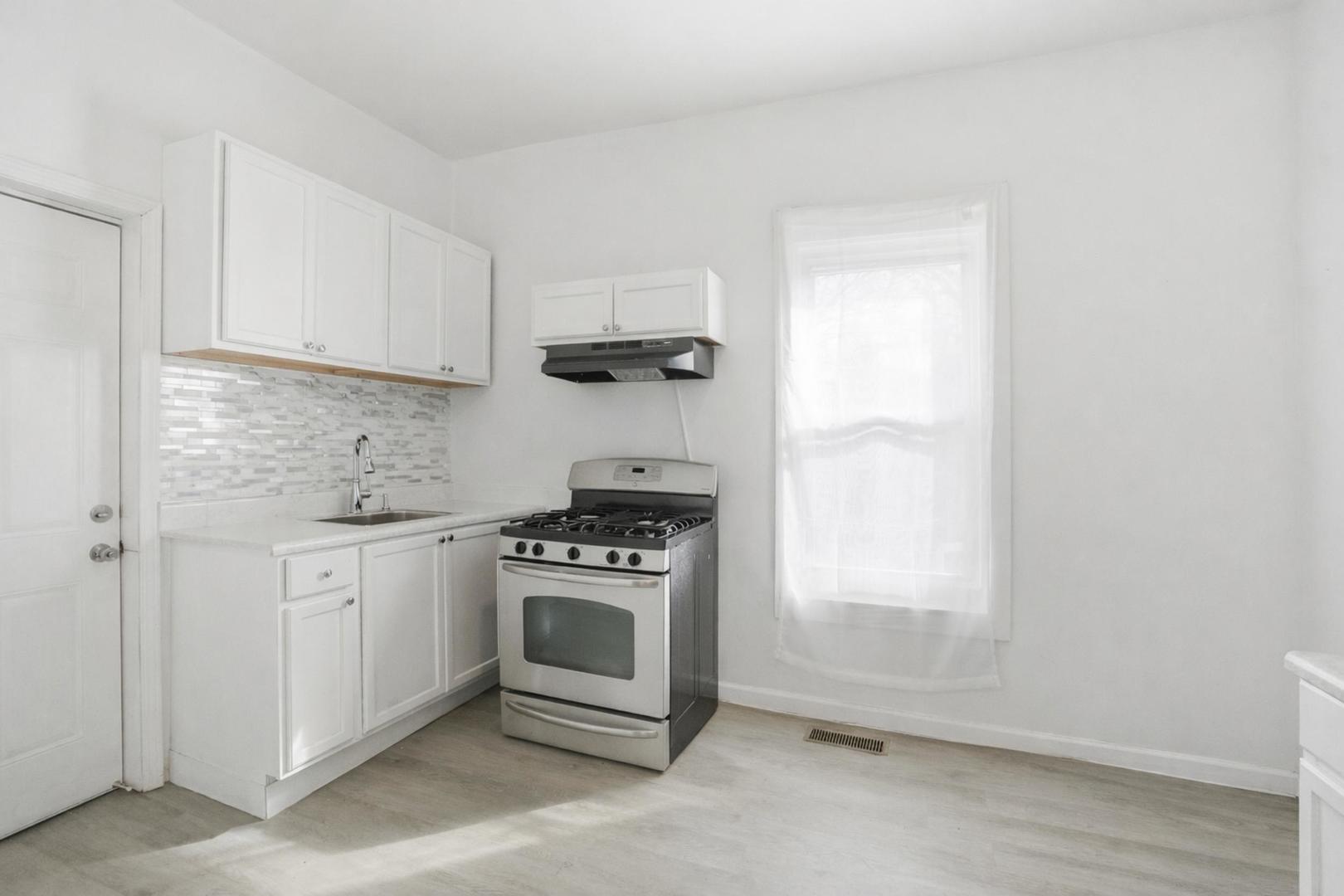 7923 South Lowe Avenue Chicago, IL 60620 - Photo 6 of 23 a kitchen with granite countertop a stove a sink and a white cabinets
