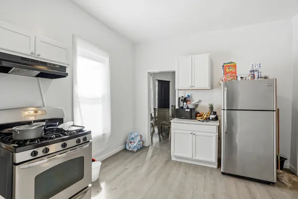 a kitchen with a refrigerator a stove a sink and cabinets