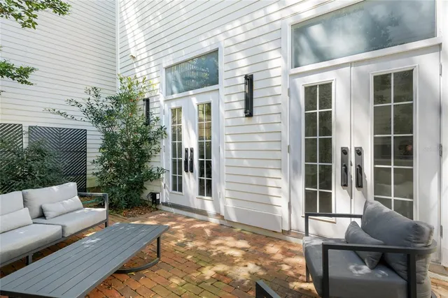 a view of a patio with couches table and chairs and potted plants