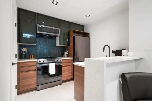 a kitchen with stainless steel appliances granite countertop a stove a sink and a refrigerator