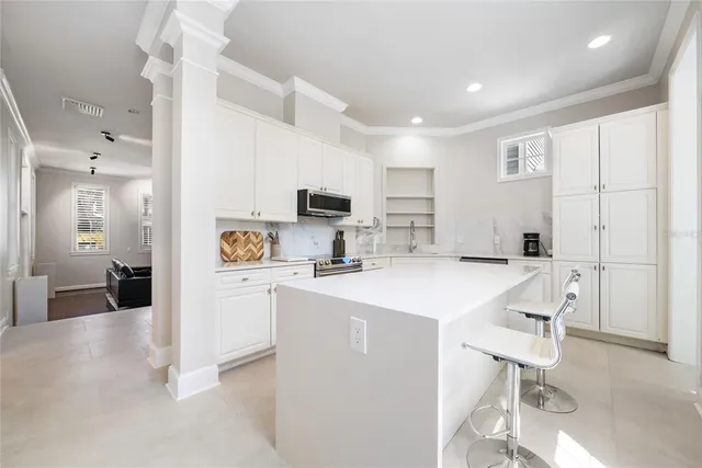 a kitchen with a sink a counter top space cabinets and stainless steel appliances