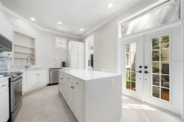 a large white kitchen with cabinets and a window