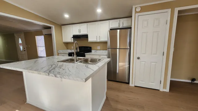 a kitchen with stainless steel appliances granite countertop a refrigerator a sink and a stove