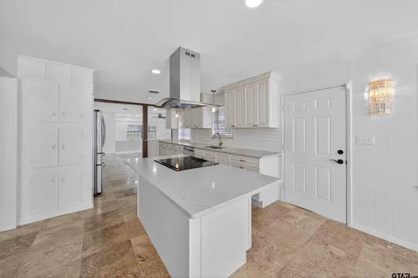 a kitchen with a sink a stove a refrigerator and white cabinets