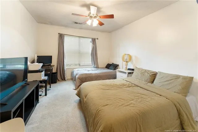 a bed room with two bed and a flat screen tv