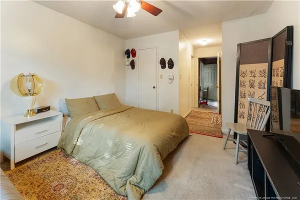 a spacious bedroom with a bed and a chandelier