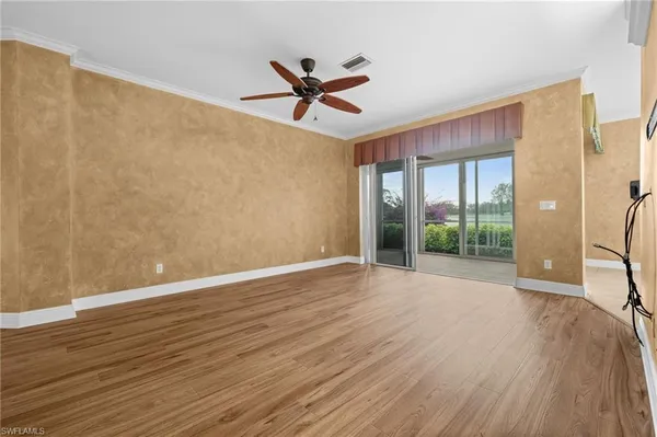 a view of a livingroom with wooden floor and a ceiling fan