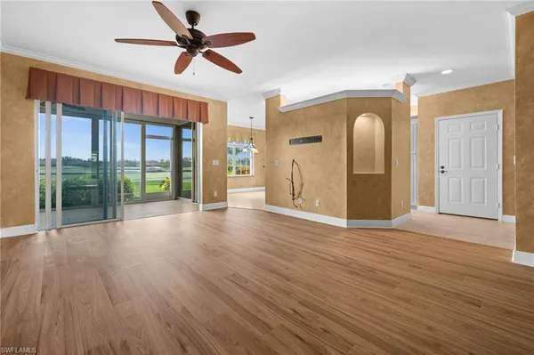 a view of a livingroom with wooden floor and a ceiling fan