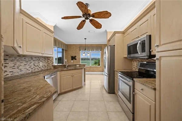 a kitchen with granite countertop a sink stainless steel appliances and cabinets