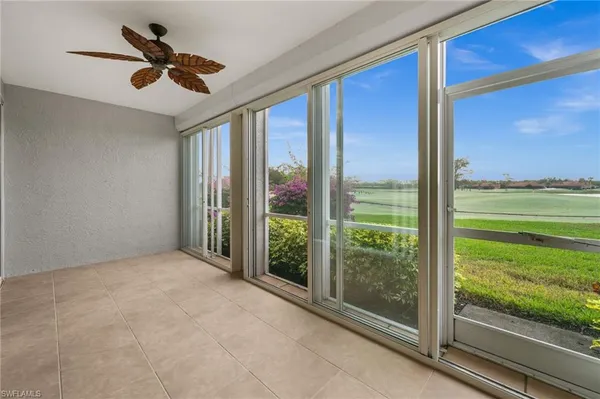 a view of a room with a floor to ceiling window and a ceiling fan