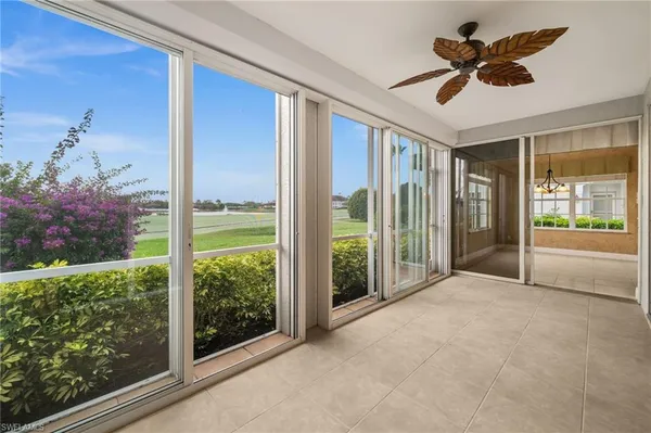 a view of a room with a floor to ceiling window and a ceiling fan