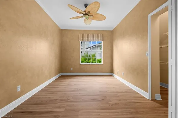 an empty room with windows and a ceiling fan