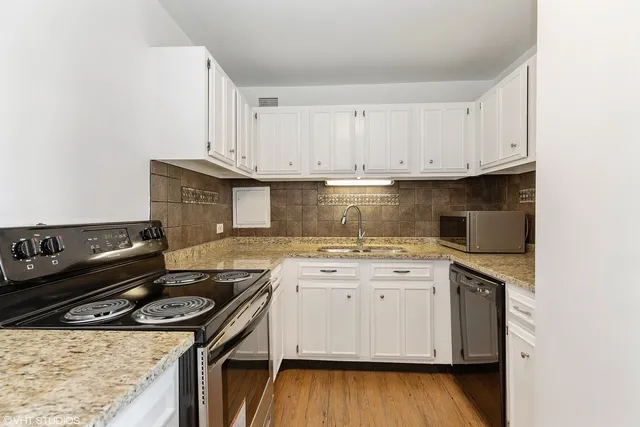a kitchen with a stove and white cabinets