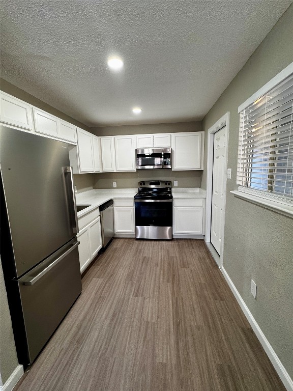202 West N Loop Boulevard, Unit A Austin, TX 78751 - Photo 2 of 6 a kitchen with granite countertop a refrigerator oven a sink dishwasher and wooden floor