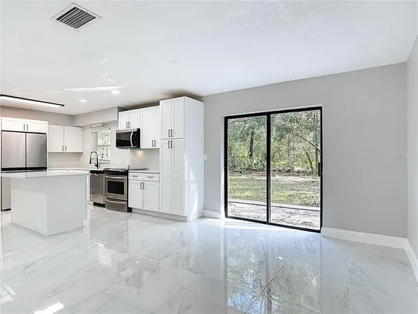 a kitchen with white cabinets and appliances