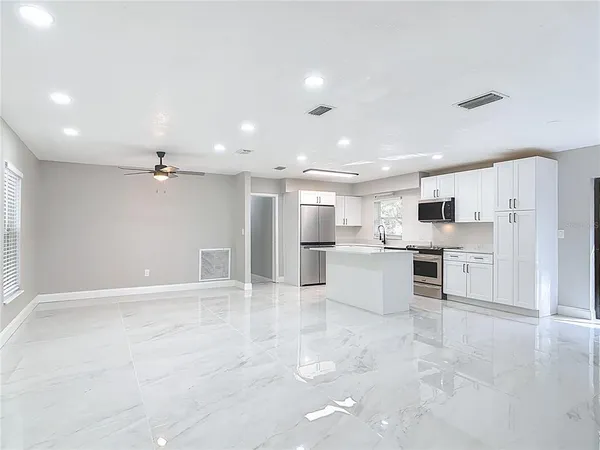 a view of kitchen with kitchen island white cabinets and refrigerator