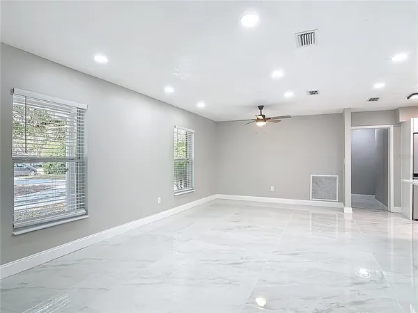an empty room with windows and cabinet