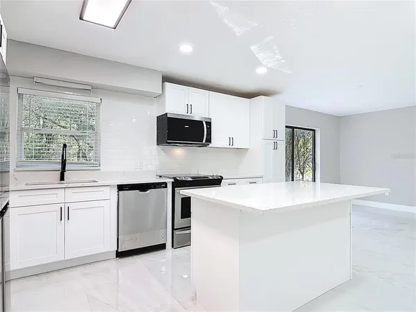a kitchen with stainless steel appliances a sink stove and cabinets