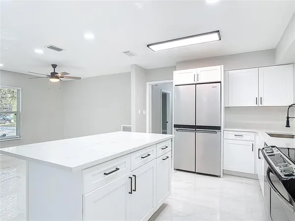 a kitchen with white cabinets and white appliances
