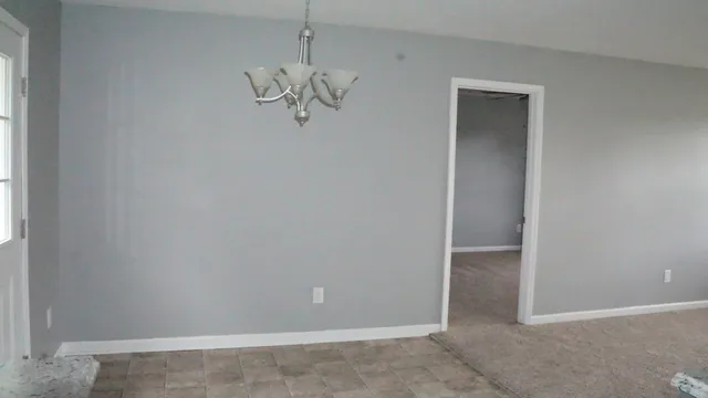 an empty room with chandelier fan