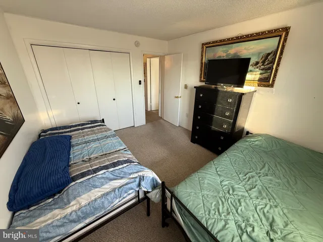 a bedroom with a bed and flat tv screen