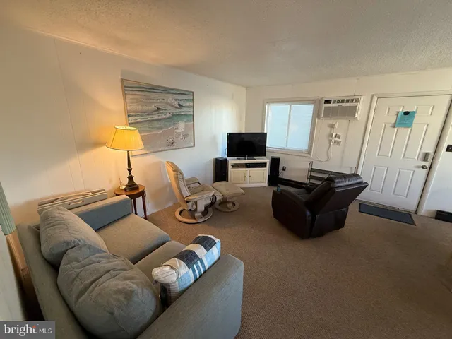 a living room with furniture a flat screen tv and a window