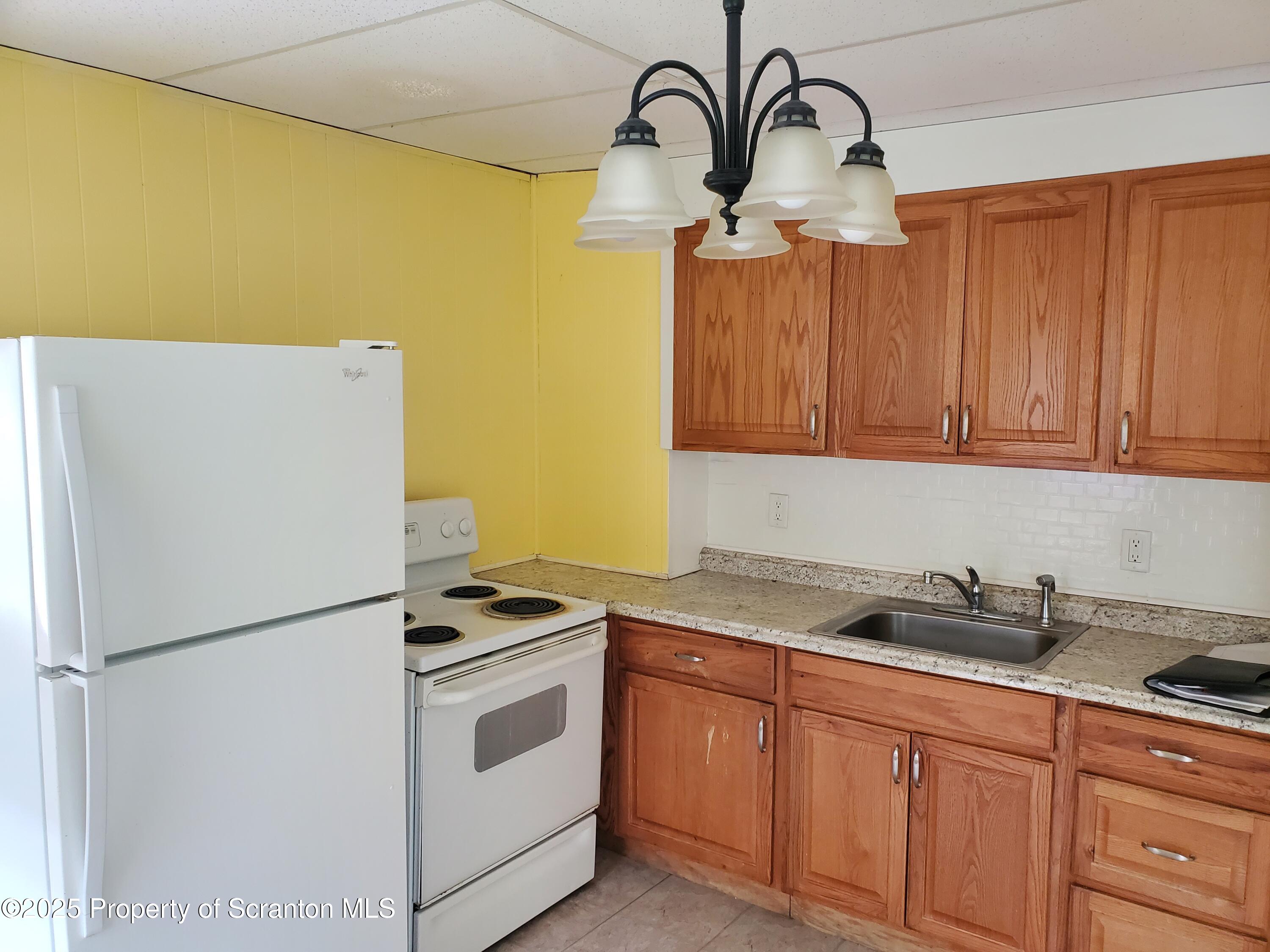 333 Spring Street Scranton, PA 18508 - Photo 11 of 43 a kitchen with stainless steel appliances granite countertop white refrigerator a stove a sink and dishwasher