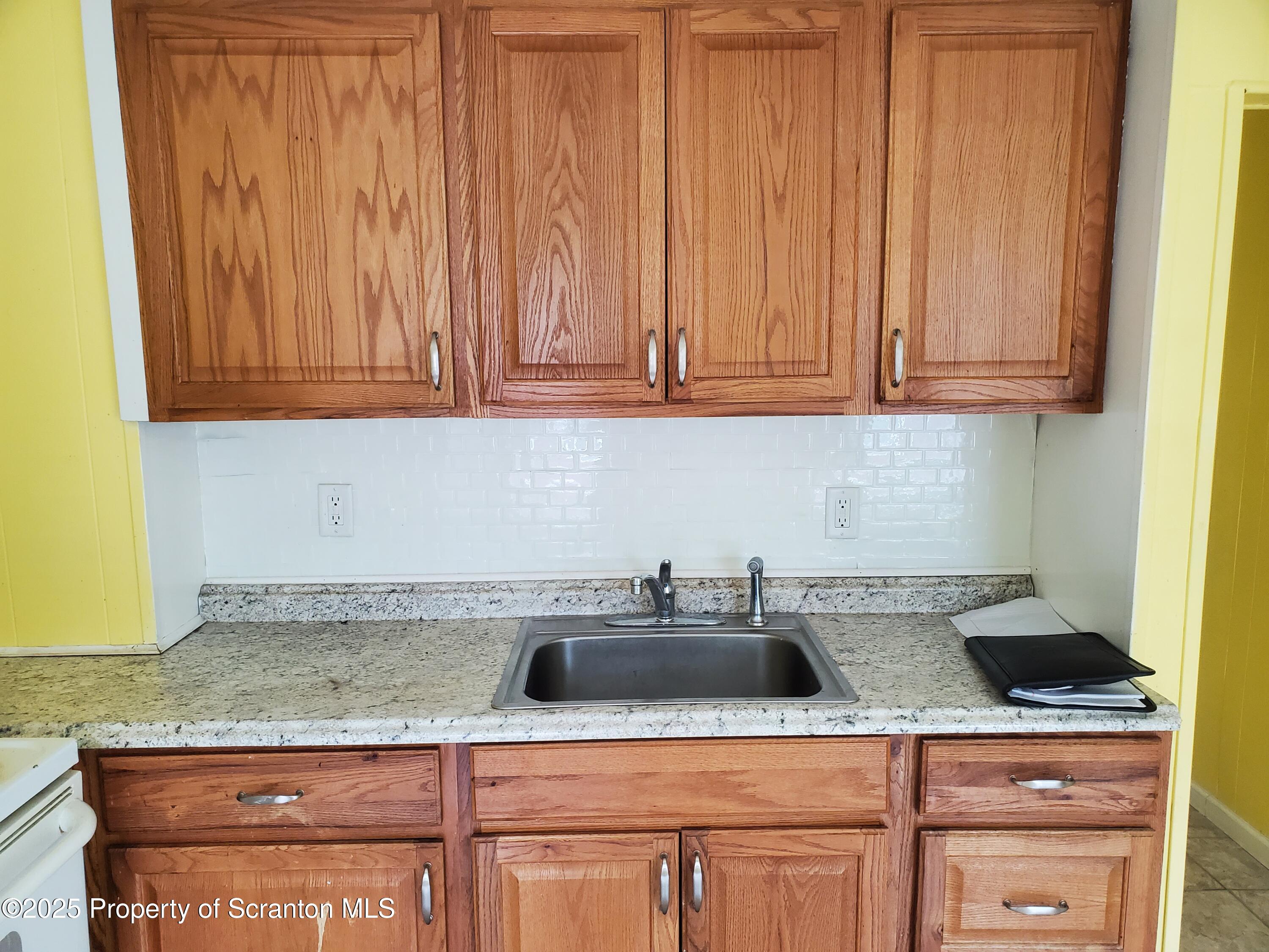 333 Spring Street Scranton, PA 18508 - Photo 12 of 43 a kitchen with stainless steel appliances granite countertop a sink a stove and cabinets
