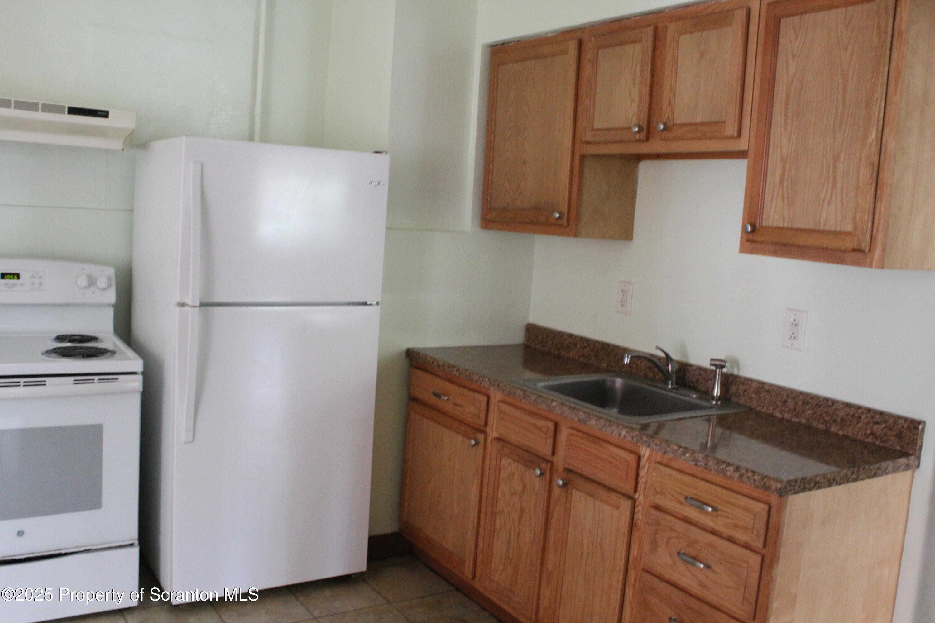 333 Spring Street Scranton, PA 18508 - Photo 13 of 43 a kitchen with granite countertop a refrigerator a stove a sink and dishwasher