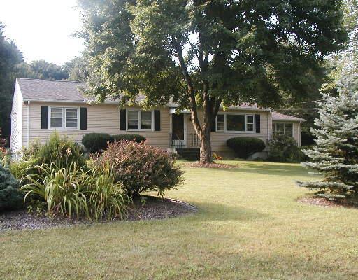 124 Rogers Road Orange, CT 06477 - Photo 1 of 1 a front view of house with yard and trees around