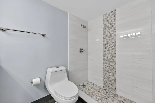 a white toilet sitting next to a shower