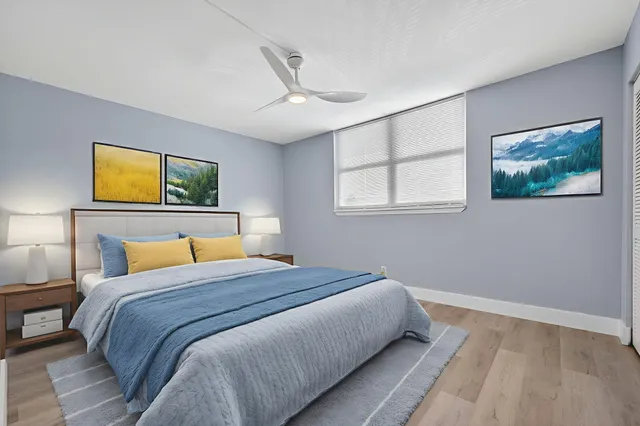 a bedroom with a bed and a painting on the wall