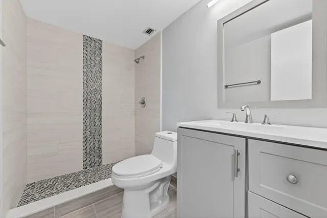 a bathroom with a sink a toilet and shower