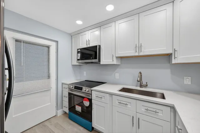 a kitchen with white cabinets and white appliances