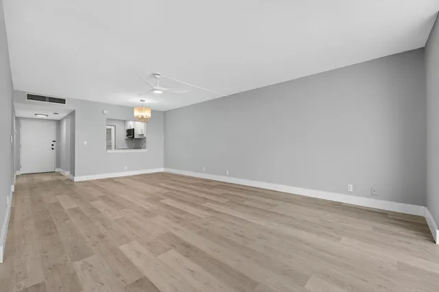 a view of empty room with wooden floor and windows