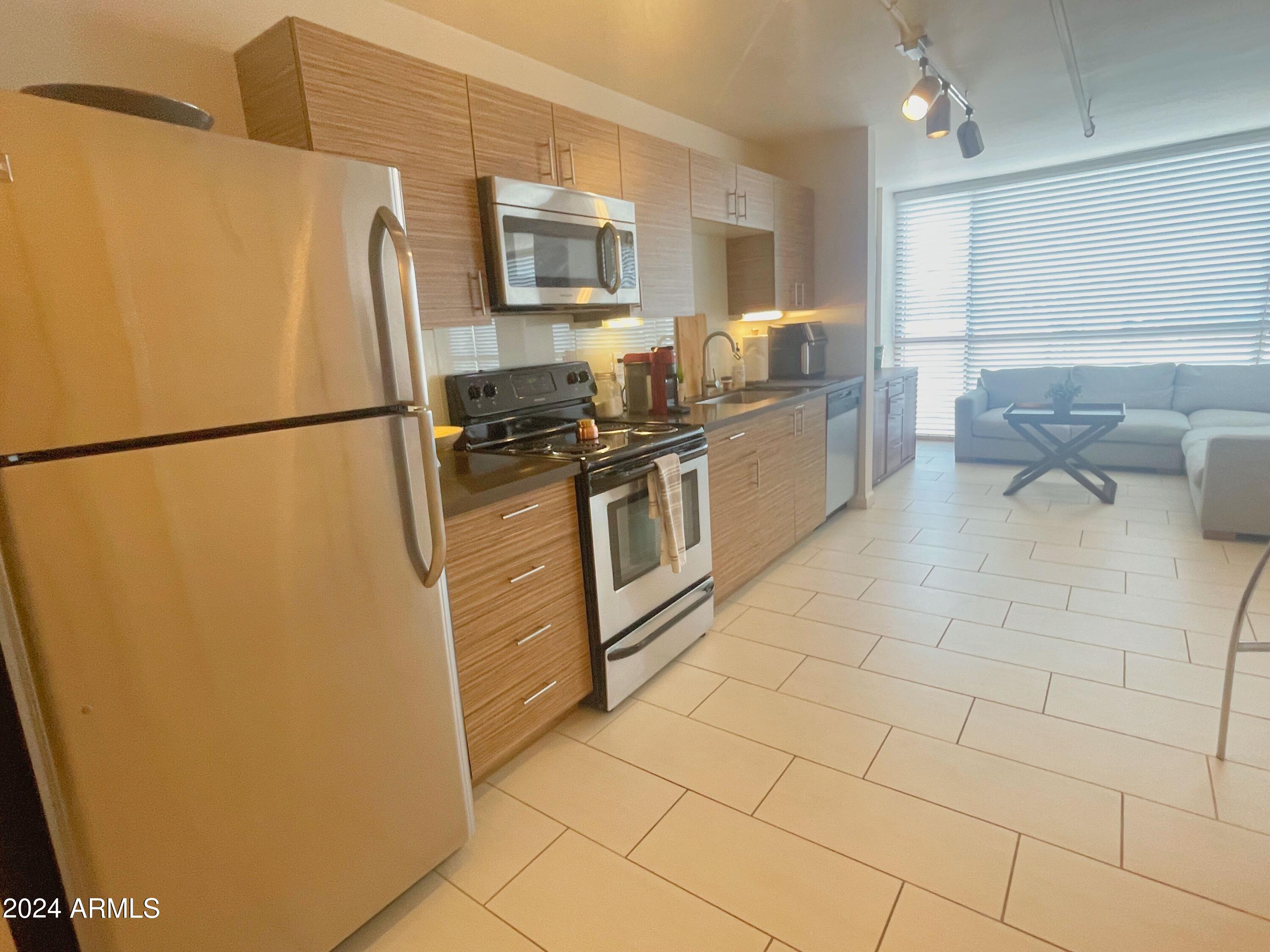 535 West Thomas Road, Unit 401 Phoenix, AZ 85013 - Photo 3 of 22 a kitchen with stainless steel appliances a refrigerator a sink a stove top oven a counter space and cabinets