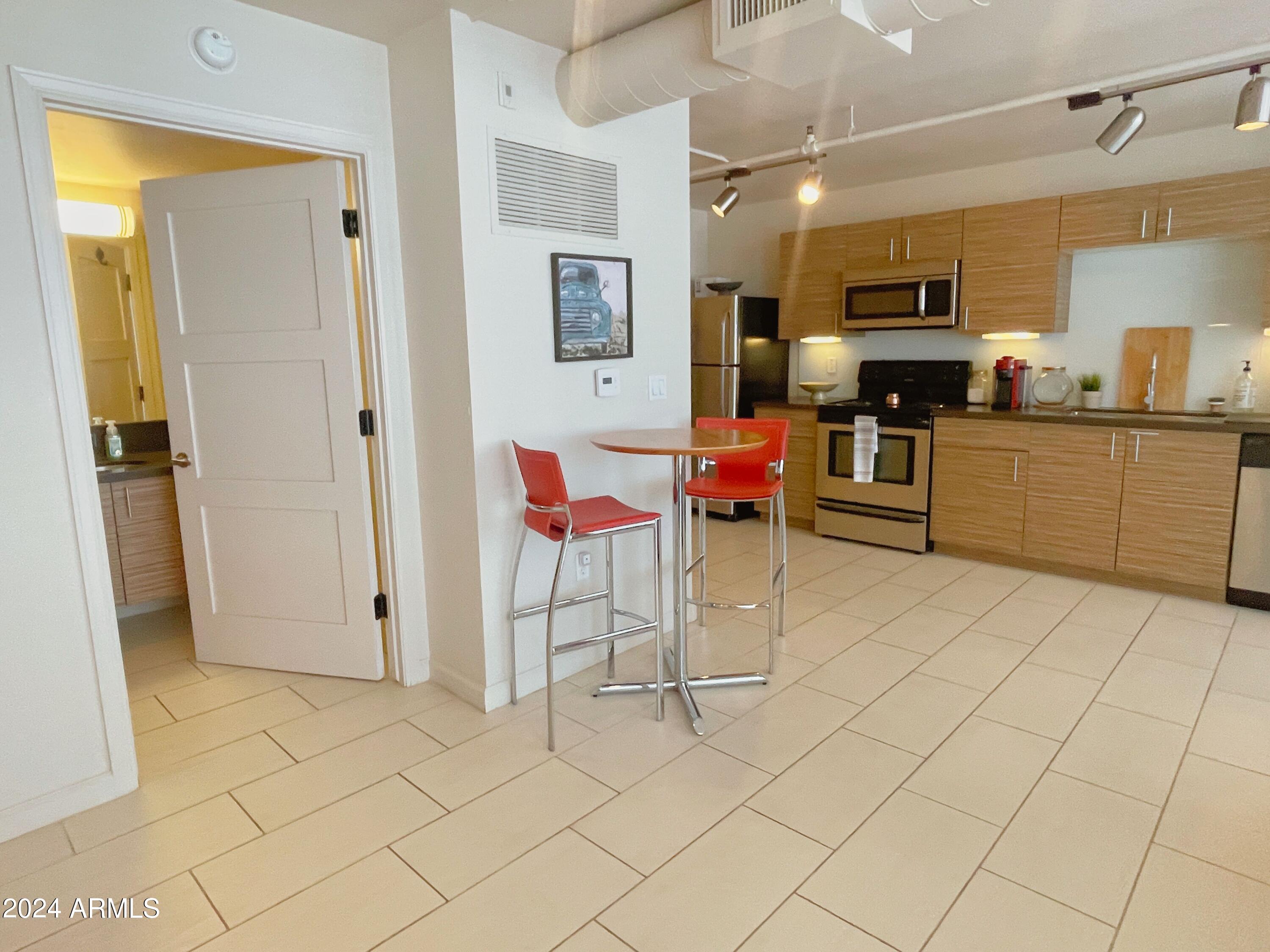 535 West Thomas Road, Unit 401 Phoenix, AZ 85013 - Photo 4 of 22 a kitchen with stainless steel appliances kitchen island granite countertop a refrigerator and microwave