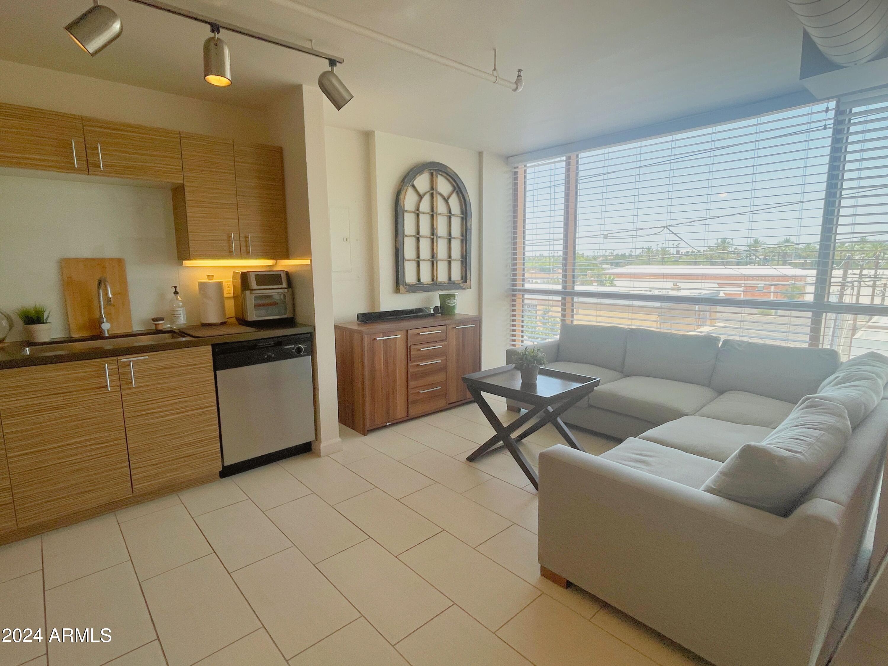 535 West Thomas Road, Unit 401 Phoenix, AZ 85013 - Photo 5 of 22 a living room with furniture a window and a dining table