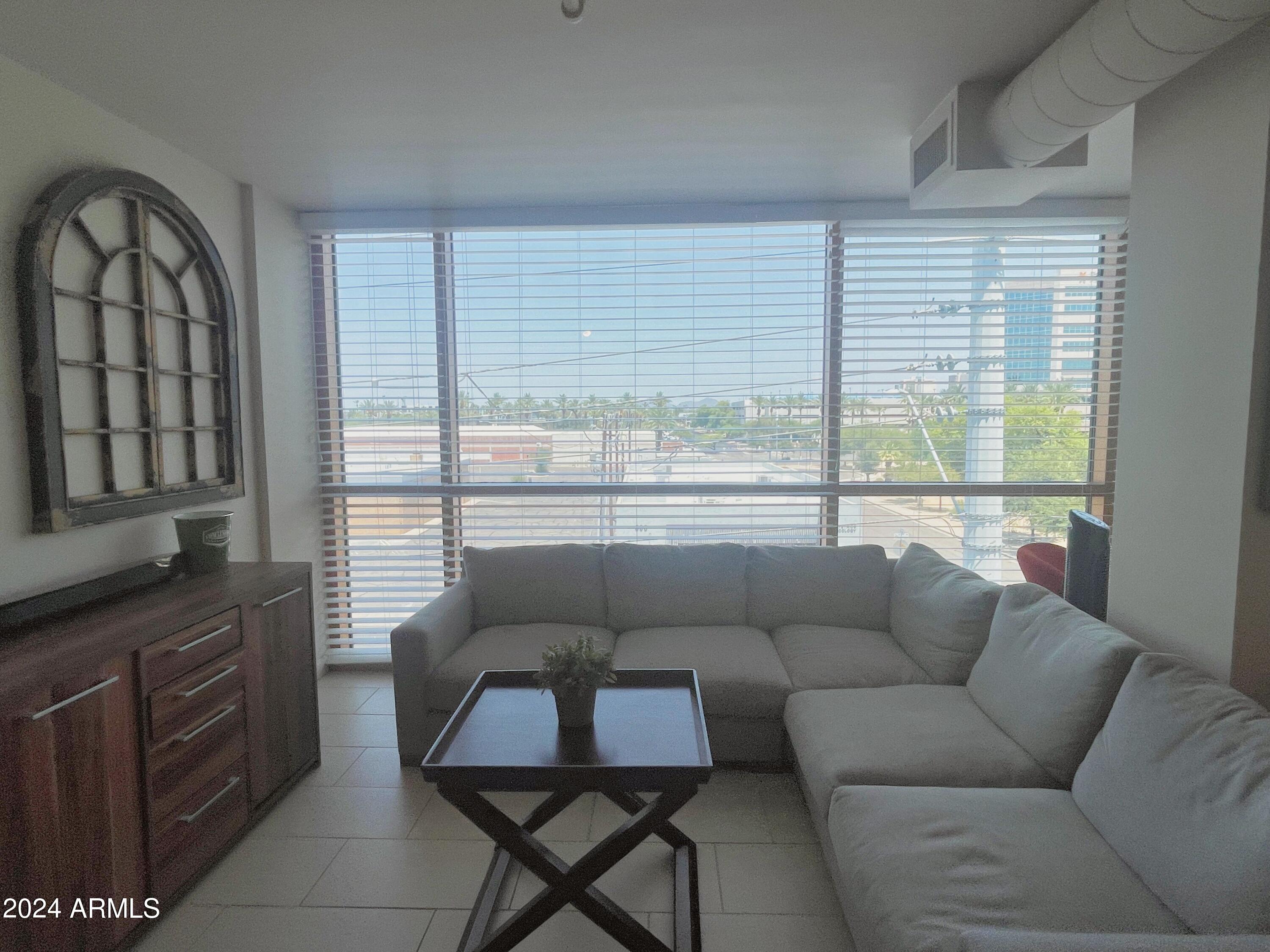 535 West Thomas Road, Unit 401 Phoenix, AZ 85013 - Photo 6 of 22 a living room with furniture and a floor to ceiling window