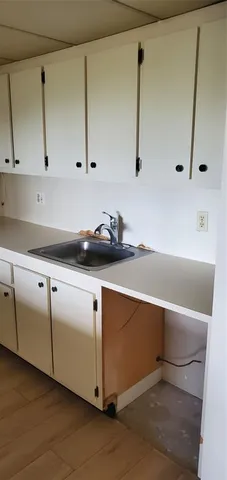 a kitchen with cabinets appliances and wooden floor