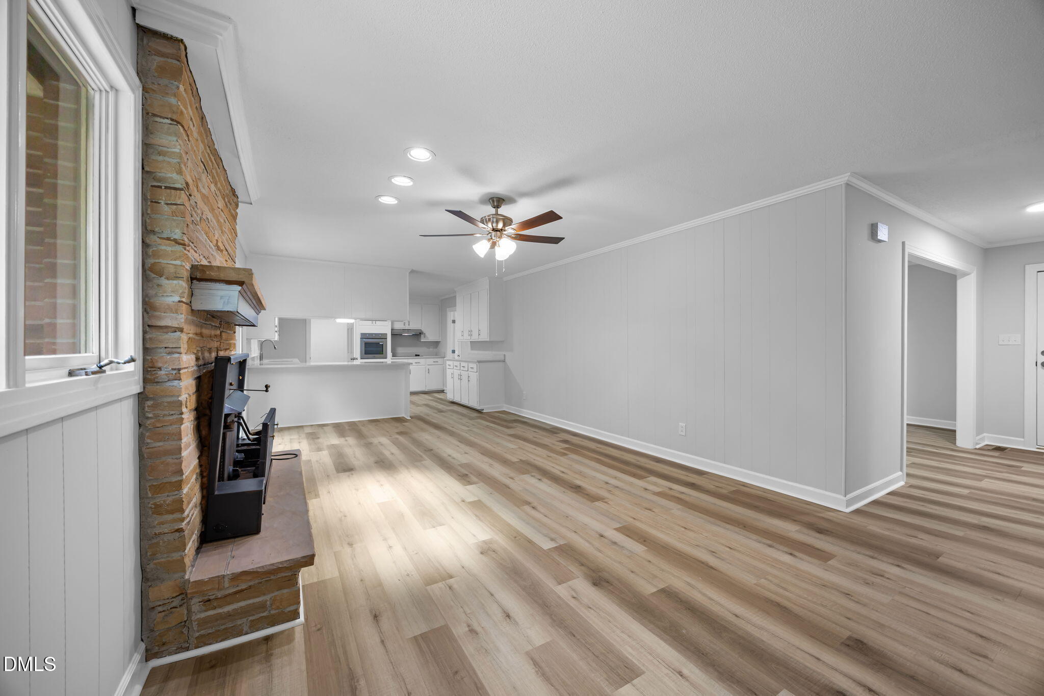 1341 Bear Trap Road Williamston, NC 27892 - Photo 12 of 42 a view of a kitchen and an empty room with wooden floor and windows